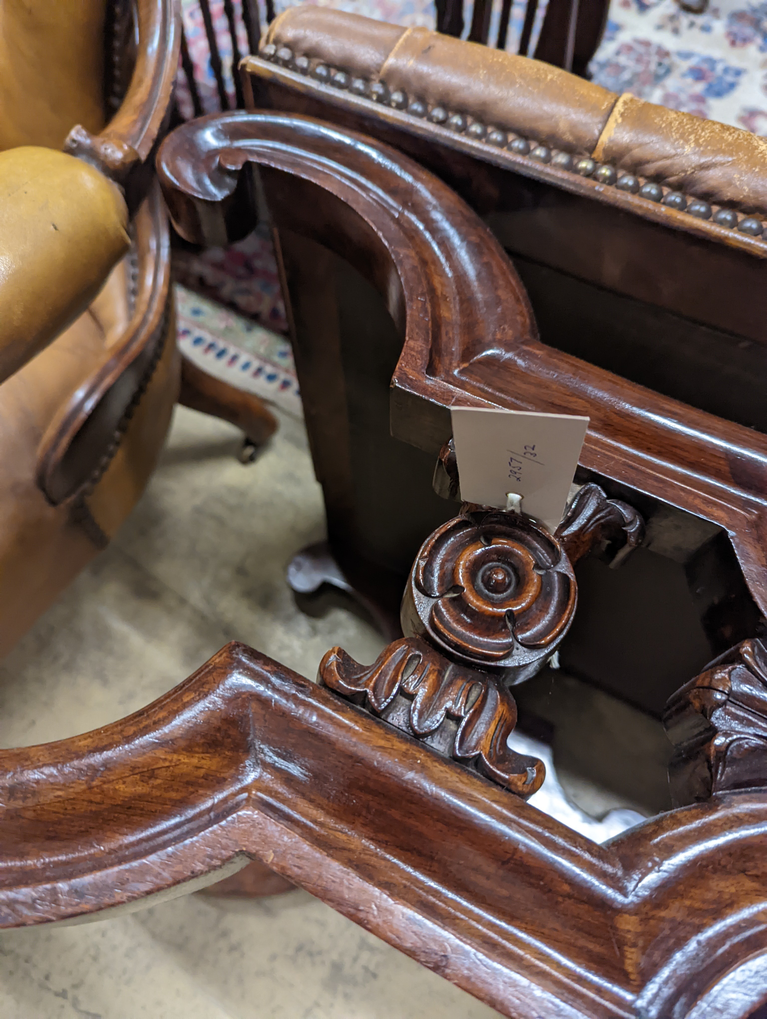 A Victorian carved X-framed rosewood footstool, upholstered in a buttoned brown leather, width 90cm depth 57cm height 42cm